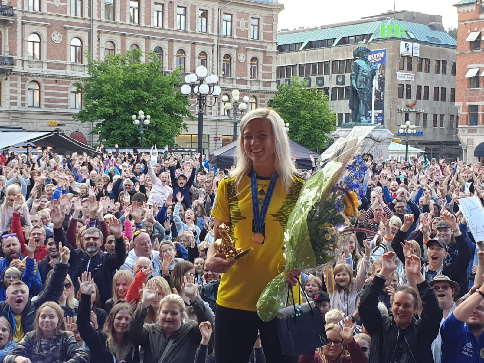Firande med publik och blommor på torget